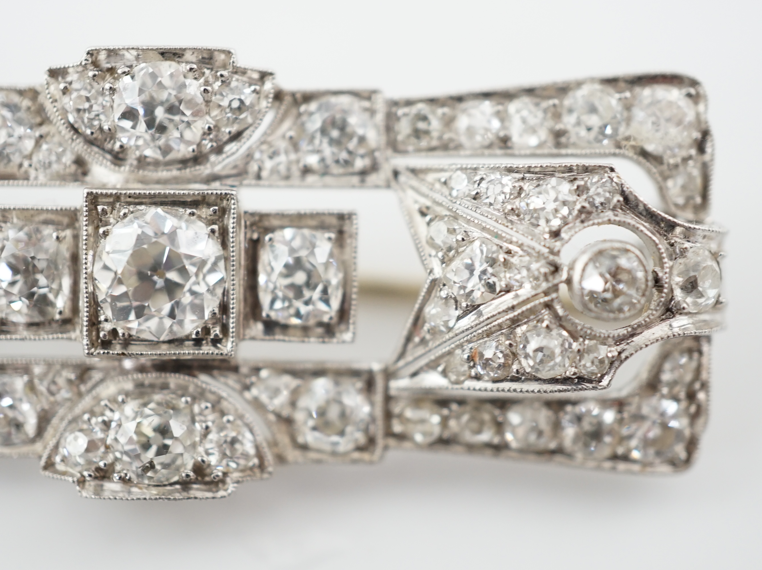 An Art Deco platinum and millegrain set diamond cluster brooch